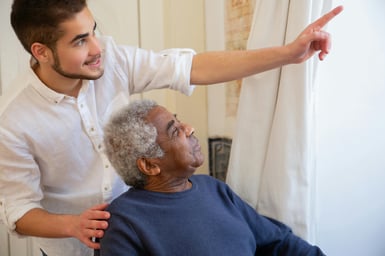 Gentle photo of an older adult being guided by a loved one, with warm lighting and soft focus on the eyes.
